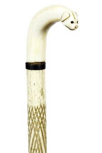 7. Whalebone Nautical Cane-Ca. 1850-A carved whale’s: 7. Whalebone Nautical Cane-Ca. 1850-A carved whale’s tooth dog with baleen eyes, baleen ring collar, whalebone shaft which is 50% cross-hatched and a metal ferrule-H. 2” x 1 ¾”, O.L. 34 ½”