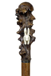 19. Briar Wood and Rabbit Cane-Ca. 1860-A large natural: 19. Briar Wood and Rabbit Cane-Ca. 1860-A large natural grown handle with an ivory long haired rabbit, woven leather collar, 1” malacca shaft and a metal ferrule-H. 2” x 6 ½”, O.L. 37”