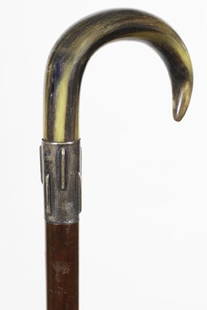 20. Horn Dress Cane-Ca. 1870-An American buffalo horn: 20. Horn Dress Cane-Ca. 1870-An American buffalo horn crook handle, unmarked silver ornate collar, snakewood shaft and a metal ferrule-H. 4” x 3”, O.L. 36”
