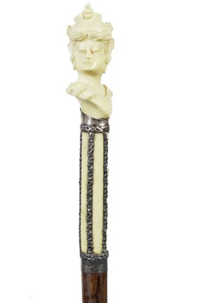 167. Art Nouveau Dress Cane-Ca. 1890-A carved ivory: 167. Art Nouveau Dress Cane-Ca. 1890-A carved ivory lady with her fancy hat atop, signed pair of sterling collars, hardwood shaft and a spear ferrule-H. 5” x 1 ¼”, O.L. 30 ½”