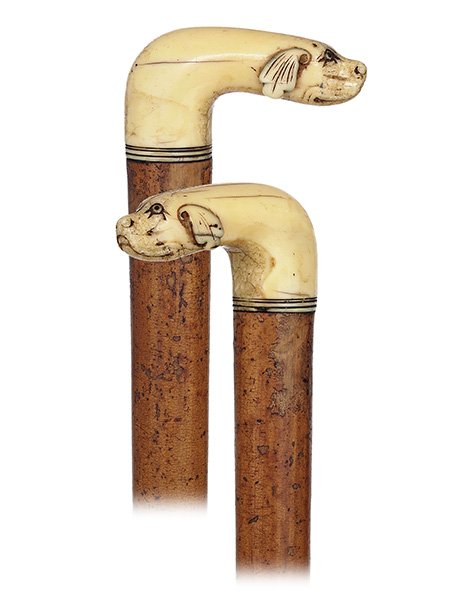 85. Early Figural Ivory Cane-Ca. 1780-L-shaped walrus: 85. Early Figural Ivory Cane-Ca. 1780-L-shaped walrus ivory handle carved with a dog head at the front, malacca shaft and a brass ferrule. The bold proportions of the handle and naïve depiction of th