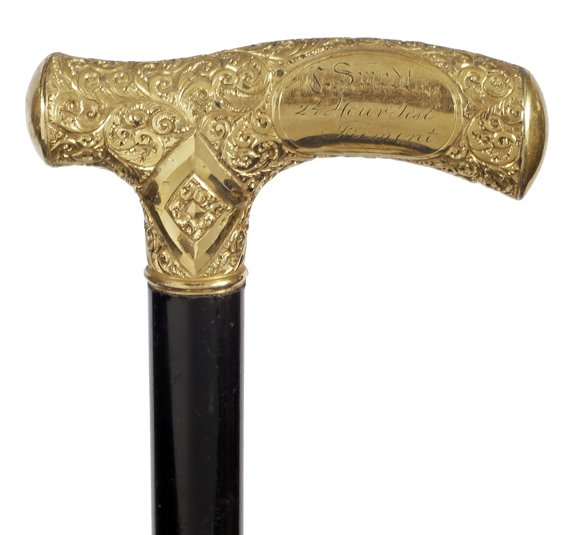 131. Ornate Gold Dress Cane-Ca. 1895-An ornate: 131. Ornate Gold Dress Cane-Ca. 1895-An ornate gold-filled presentation handle in fine condition, firmly attached to the nice ebony shaft and a metal ferrule-H. 3 ¾” x 1 ¾”, O.L. 35 ½”-$300-$