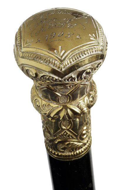 169. Gold Dress Cane-Dated 1905-A gold-filled ornate: 169. Gold Dress Cane-Dated 1905-A gold-filled ornate presentation dress cane in nice condition, ebony shaft and a metal ferrule-H. 1 ½” x 2 ½”, O.L. 37”-$250-$350