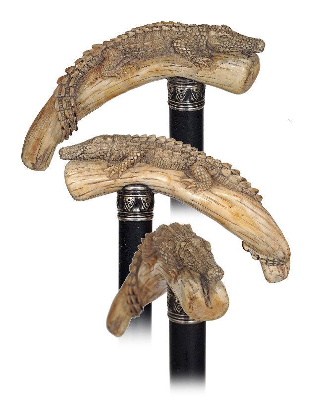 51. Warthog Figural Cane-Ca. 1900-Large warthog: 51. Warthog Figural Cane-Ca. 1900-Large warthog tooth carved with an alligator, ebony shaft with a chased silver collar and a horn ferrule. The reptile has an impressive head and powerful jaws and i