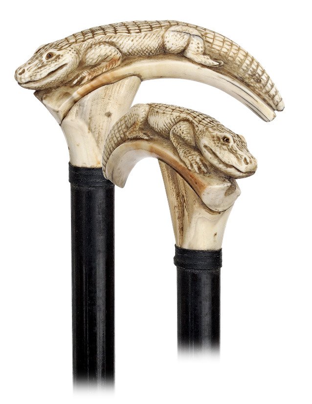 126. Warthog Ivory Figural Cane-Ca. 1900-Large warthog: 126. Warthog Ivory Figural Cane-Ca. 1900-Large warthog tooth carved with a large aquatic reptile which could be a crocodile or a varan, ebony shaft with a bound leather collar and a stag horn ferrule.