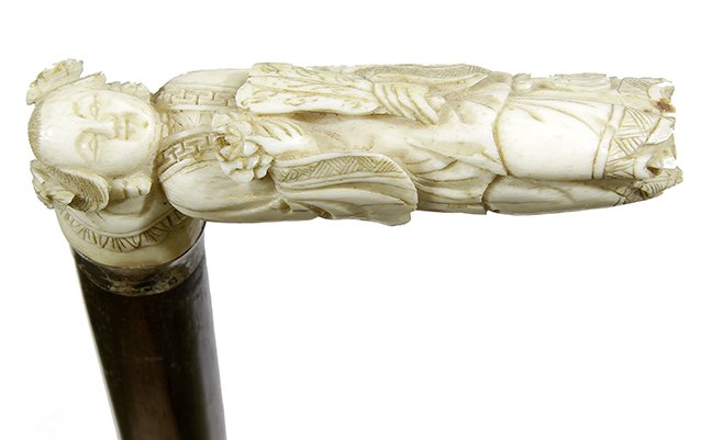 13. Johnny Winter Chinese Cane- Ca. 1880- A carved bone: 13. Johnny Winter Chinese Cane- Ca. 1880- A carved bone Chinese figure, small silver metal collar, exotic wood shaft and a stopper ferrule. H.- 4” x 1 ½” O.L.- 38 ½” $400-$500 NOTE:The first 