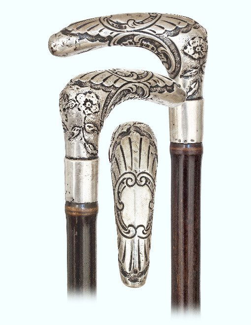 130. Silver Day Cane -Ca. 1890-Large L-shaped silver: 130. Silver Day Cane-Ca. 1890-Large L-shaped silver handle with a slightly arched and pointed hand rest well chased and engraved in the Baroque taste with rich scrolls, flowers and other decorative el