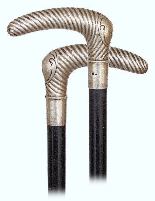 135. Silver Dress Cane-Ca. 1890-L-shaped silver handle: 135. Silver Dress Cane-Ca. 1890-L-shaped silver handle with a pointed hand rest chased with a twirl and a blank escutcheon at the front and fitted with an integral, plain and tapering collar. It has m