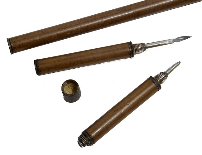 159. Writer’s System Cane- Ca. 1890- A system cane: 159. Writer’s System Cane- Ca. 1890- A system cane which has a fountain pen tip, an ink bottle and an ink scraper, maple shaft and a metal ferrule. O.L- 36“ $200-$400.