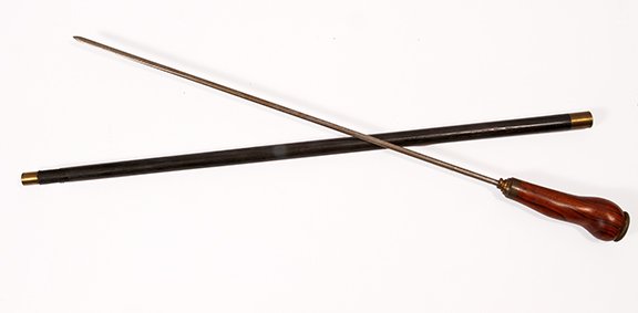 8. Exotic Wood Sword Cane- Ca. 1920- An exotic massive: 8. Exotic Wood Sword Cane- Ca. 1920- An exotic massive wood handle with a bronze flower cartouche atop, brass collar, ebonized shaft, brass ferrule, 23” pike blade with twist and lock mechanism. H- 
