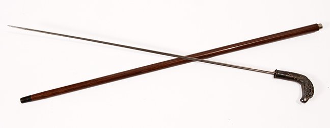 29. Eagle Sword Cane- Mid 20th Century- A heavy silver: 29. Eagle Sword Cane- Mid 20th Century- A heavy silver plate cast eagle which doubles as a bludgeon cane, exotic hardwood shaft, horn ferrule, 27 ½” three-sided blade with push/pull mechanism. H- 3