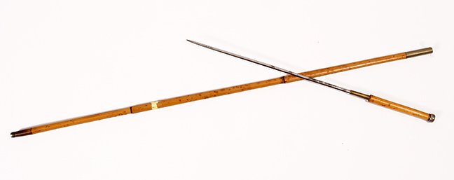 39. Diminutive Sword Cane- Ca. 1890- A small bamboo: 39. Diminutive Sword Cane- Ca. 1890- A small bamboo sword cane, silver metal collar and top, horn and metal ferrule, 11 ¼” two-sided blade with push/pull mechanism. H.- 4 ¼” x ¼” O.L.33” 