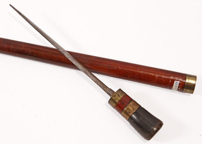 41. Horn Sword Cane- Ca. 1800- A buffalo horn handle,: 41. Horn Sword Cane- Ca. 1800- A buffalo horn handle, three brass collars, 1 ½” thick malacca shaft and a horn ferrule, 10” three-sided blade with push/pull mechanism. H.- 1 ¾” x 1 ½” O.L.-