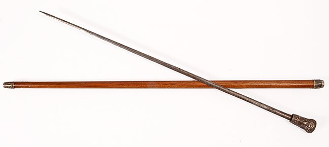 42. Silver Sword Cane- Late 19th Century- An ornate: 42. Silver Sword Cane- Late 19th Century- An ornate silver metal handle matching collar, exotic wood shaft, matching silver ferrule, 26 ½” two-sided blade with push button mechanism, engraved “Ne