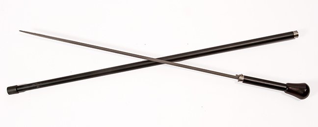 48. Dress Sword Cane- Mid 20th Century- A nice: 48. Dress Sword Cane- Mid 20th Century- A nice midcentury wood handle, silver metal collars, ebony shaft and a stopper ferrule, x-shaped blade 23 ½” blade with push button mechanism. H.- 2 ¼” x 