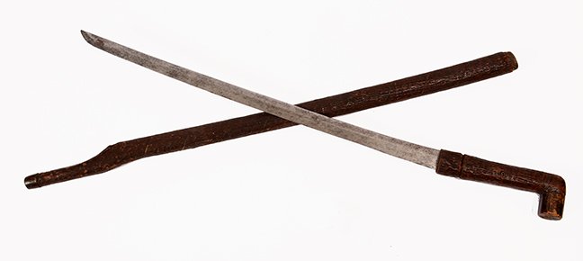 53. Full Bark Sword Cane- Ca. 1830- A full bark: 53. Full Bark Sword Cane- Ca. 1830- A full bark hardwood handle and shaft, two brass eyelets, brass ferrule, 19 ¾” two-sided blade with push/pull mechanism. H.- 5” x 2 ¼” O.L.- 32” $500-$600