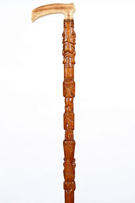 179. Northwest Coast Totem Cane - Early 20th Century-: 179. Early 20th Century- A walrus tusk carved handle, shellac hardwood shaft with various human and animal figures and a metal ferrule. H.- 4 x 1 ¾” O.L.- 36” $200-300
