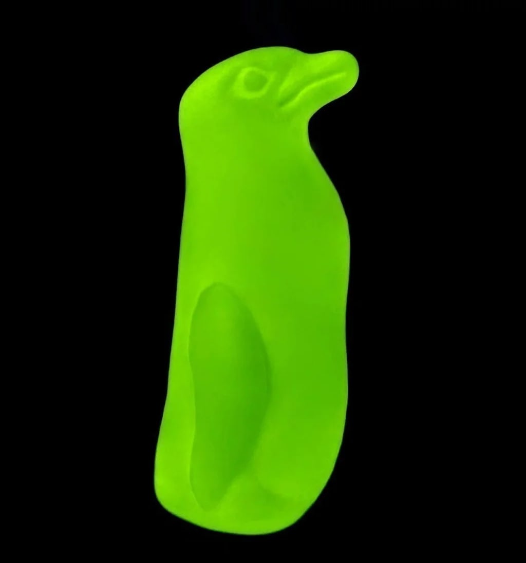 Bohemian Vaseline Uranium Glass Penguin Figurine: This uranium glass penguin figurine represents classic Bohemian decorative glass design. Made from frosted yellow uranium glass, it glows with a vivid neon reaction under UV light — a feature highly