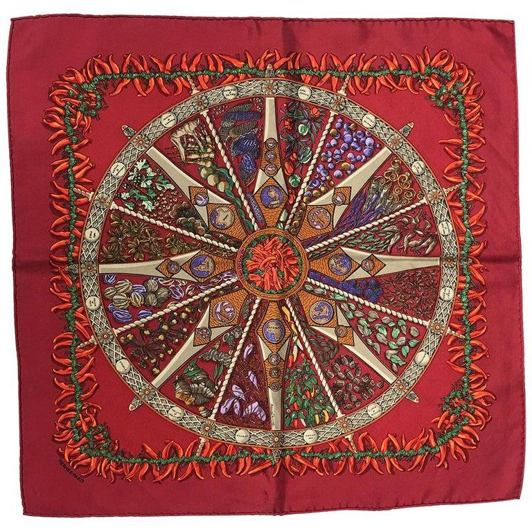 Hermes Silk Aux Pays des Epices Red Silk Pocket Square: GORGEOUS Hermes Aux Pays des Epices silk pocket square in excellent condition. Original silk screen design c2001 by Annie Faivre features an array of herbs and spices in the center wheel design surrou