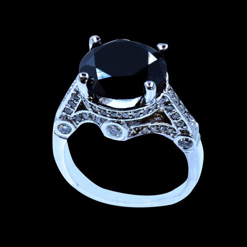 7.28CT TREATED BLACK DIAMOND 14K W/G RING: 14K W/G TREATED BLACK DIAMOND RING :6.57GRAM /TREATED BLACK DIAMOND :7.28CT/DIAMOND :0.67CT/#GVR1299 **Gorgeous 7.28 carat round cut treated Black Diamond brings mystery and wonder to this graceful ri