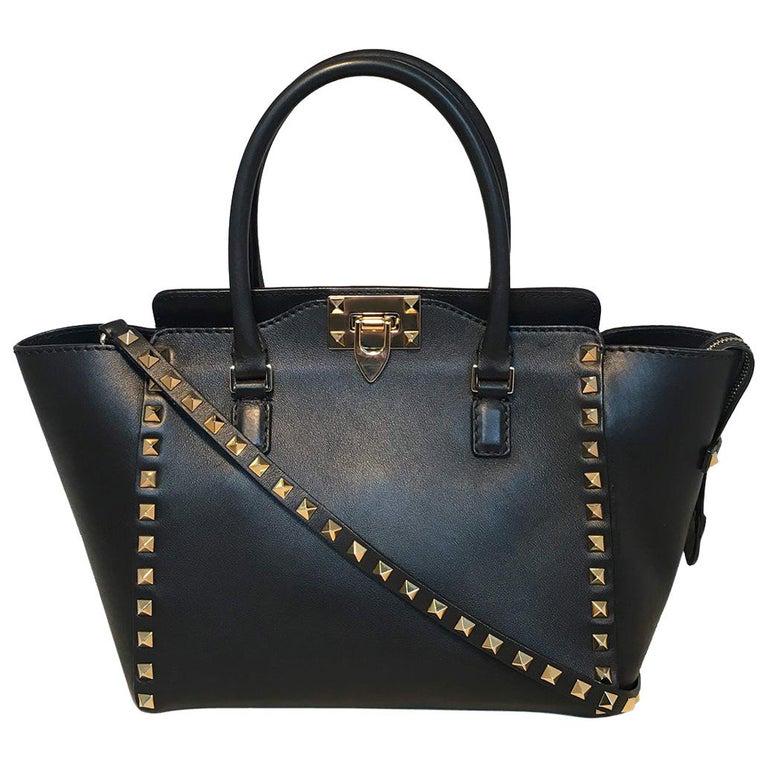 Valentino Black and Gold Double Handle Small Rockstud: Valentino Black and Gold Double Handle Small Rockstud Trapeze Tote in excellent condition. Black leather exterior trimmed with gold hardware and studs along edges and shoulder strap. Top latch and zip
