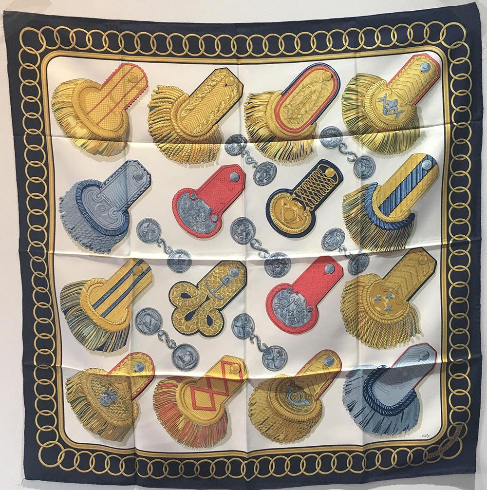Hermes Vintage Epaulettes silk Scarf c1970s in black: RARE Hermes Vintage Epaulettes silk Scarf c1970s in black in excellent condition. Original silk screen design c1975 by Caty Latham features 16 differently designed classic epaulettes in golds, greys, 