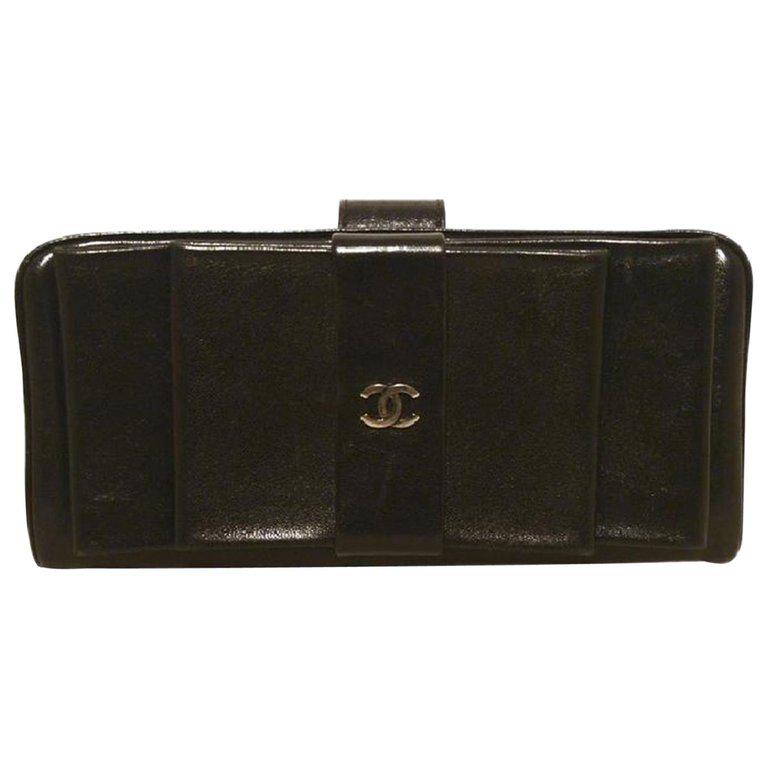 Chanel Black Leather Bow Wallet Clutch: Beautiful Chanel black leather bow wallet clutch in excellent condition. Black lambskin leather trimmed with a delicate CC silver logo along the front bow side. Top lifting closure opens to a black le