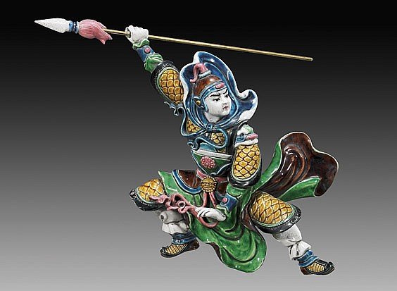 Chinese Glazed Figural Roof Tile: Chinese glazed pottery or soft paste porcelain roof tile; of an animated warrior figure, in dynamic leaping or crouching pose and holding a spear above his head, wearing colorful armour; L: 16", lucit