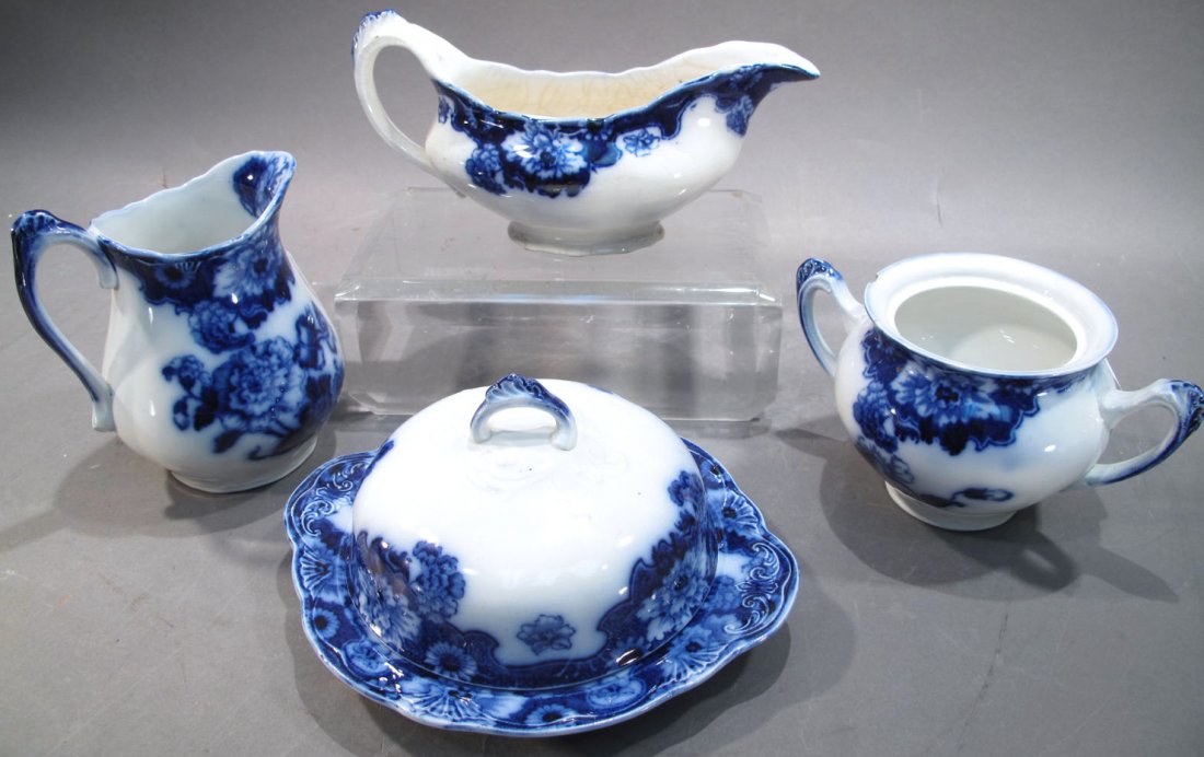 CAMBRIDGE ENGLAND FLOW BLUE CHINA. Four pieces.: CAMBRIDGE ENGLAND FLOW BLUE CHINA. Four pieces. Including a covered butter dish, creamer & sugar(note: missing lid) and a gravy boat.