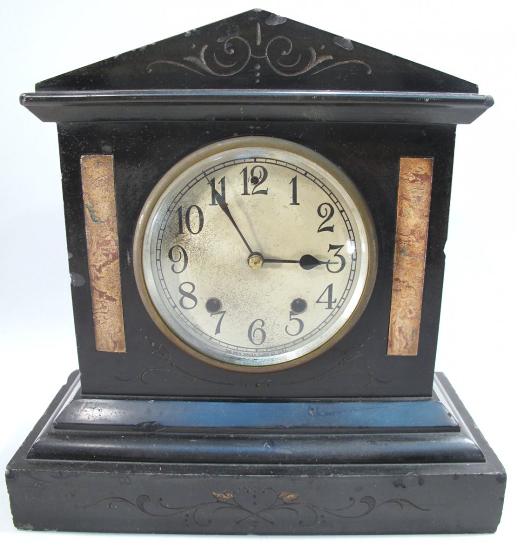 BEAUTIFULLY CARVED BLACK MANTLE CLOCK. With faux: BEAUTIFULLY CARVED BLACK MANTLE CLOCK. With faux marble inlay. Made by "The New Haven Clock Co.".