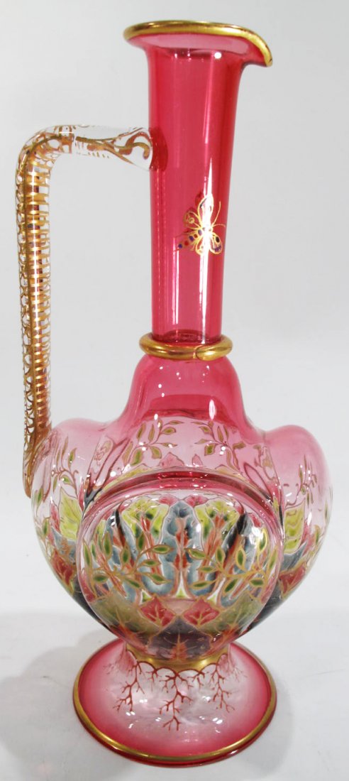 CRANBERRY FOOLED GLASS MOSER EWER. With a molded: CRANBERRY FOOLED GLASS MOSER EWER. With a molded spout, decorated with flowers and foliage. Multi colored. 7 1/4"h.
