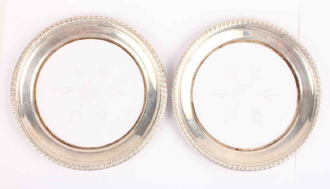 PAIR OF ETCHED GLASS STERLING SILVER WINE COASTERS: PAIR OF ETCHED GLASS STERLING SILVER WINE COASTERS Pair of sterling silver rimmed wine coaster with floral etched glass bottoms. Lot Location: #1 - Manor's Gallery Weight: 135.0 grams Size: 5.5" Shipp