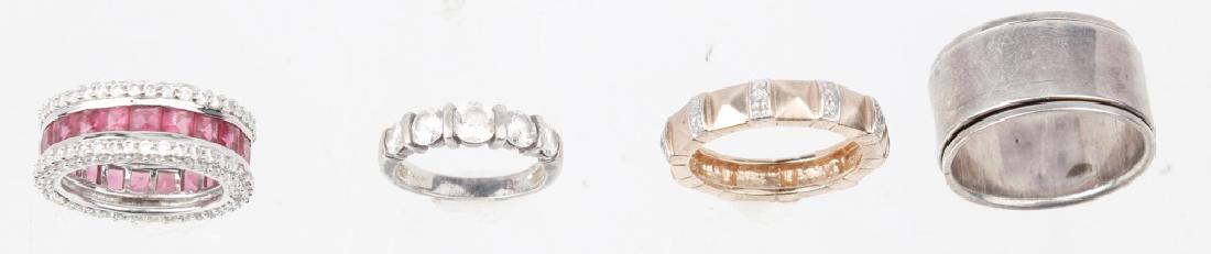 STERLING SILVER BAND RINGS - LOT OF 4: STERLING SILVER BAND RINGS - LOT OF 4 Lot of four sterling silver band rings. (1) rose gold over silver, (1) sterling silver and movable, (1) cz, and (1) pink topaz and cz. Weight: 21.6 g