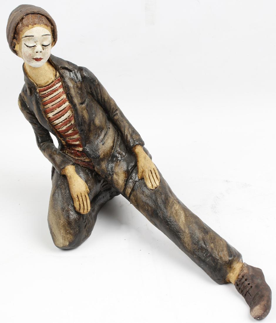 HAND SCULPTED CERAMIC CLOWN FIGURINE: HAND SCULPTED CERAMIC CLOWN FIGURINE Hand sculpted clown figurine. Crafted from clay and hand glazed with black, red, white and tan. Unsigned. Size: 16" x 13"