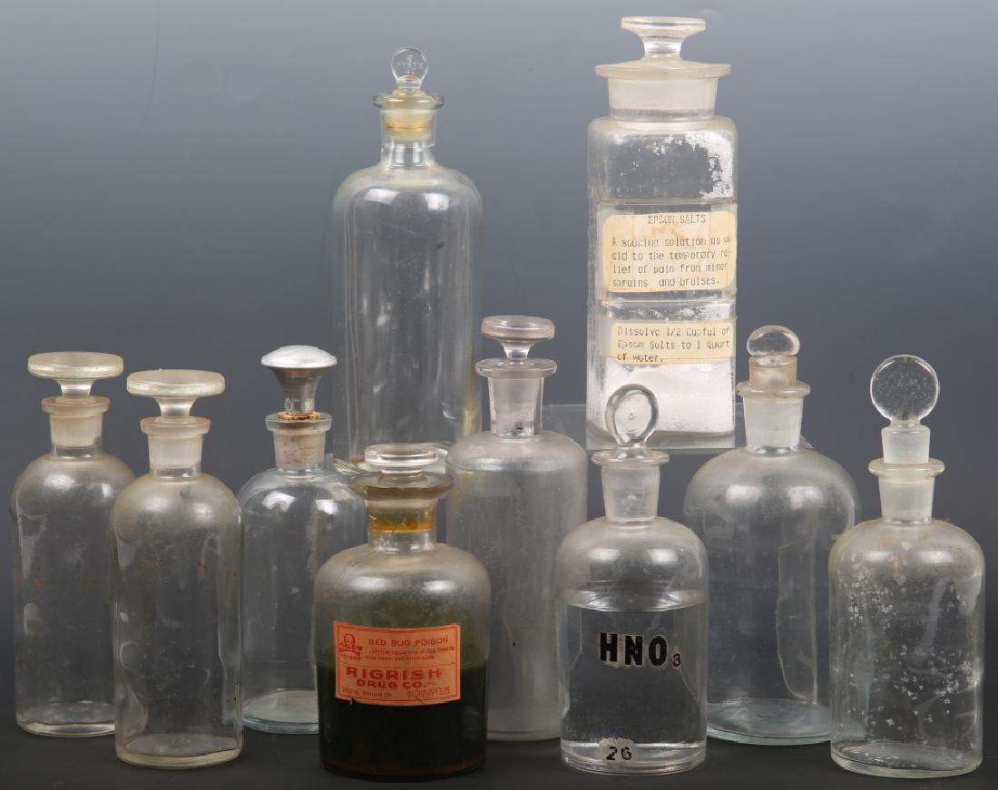 APOTHECARY CLEAR GLASS BOTTLES - LOT OF 10: APOTHECARY CLEAR GLASS BOTTLES - LOT OF 10 Apothecary clear glass bottles - lot of 10. One bottle with epson salt label and contents, one bottle with bed bug poison label and contents, One bottle with