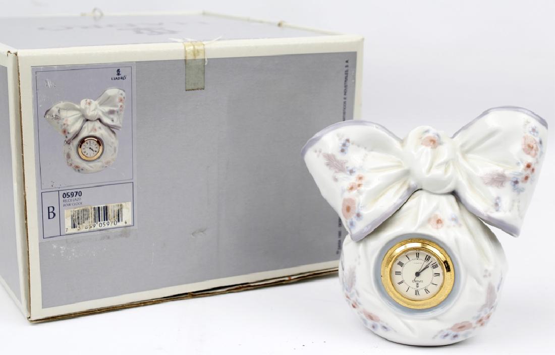 LLADRO PORCELAIN BOW CLOCK #5970: LLADRO PORCELAIN BOW CLOCK #5970 Lladro porcelain figurine "Bow Clock" number 5970. Hand crafted in Spain and in original box. Size: 5"