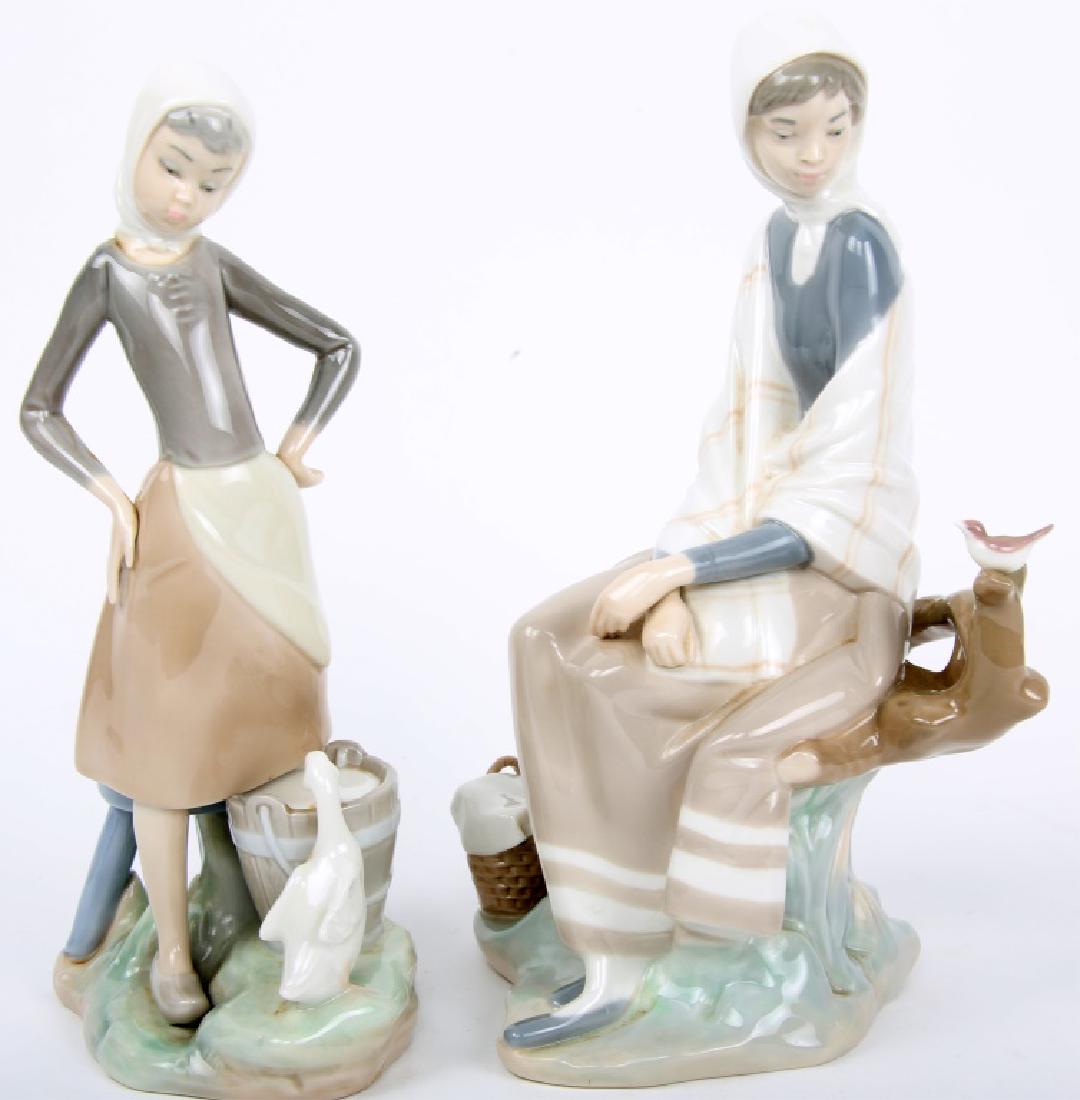 LLADRO PORCELAIN FIGURINES - LOT OF 2: LLADRO PORCELAIN FIGURINES - LOT OF 2 Lot of two Lladro of Spain porcelain figurines, to include one of girl and goose drinking from pail, and one of woman seated on tree branch with bird. Size: 9.5"