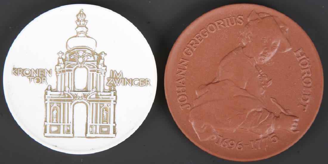 MEISSEN GERMAN PORCELAIN MEDALS - LOT OF 2: MEISSEN GERMAN PORCELAIN MEDALS - LOT OF 2 Lot of 2 Meissen Germany porcelain medals, one copper tone Porzellan Museum Johann Gregorius, and one white Kronen Tor Im Zwinger. One accompanied by box. Si