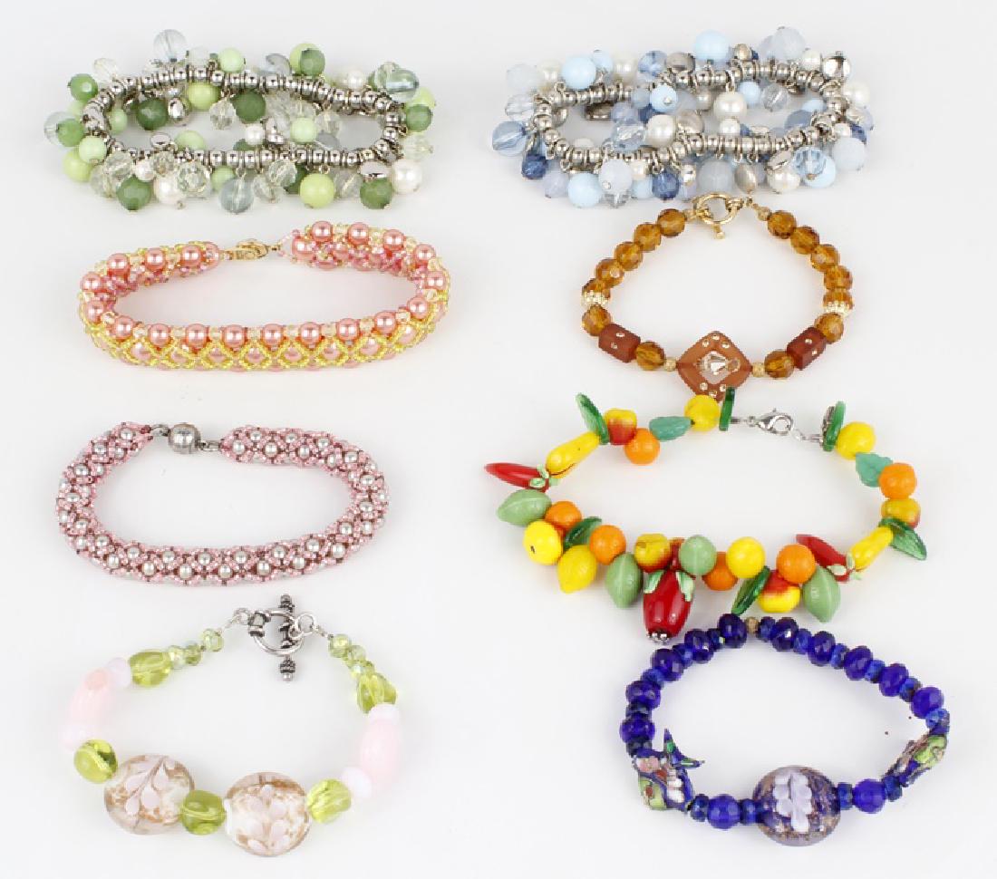 COSTUME BRACELETS - LOT OF 8: COSTUME BRACELETS - LOT OF 8 Lot of 8 assorted costume bracelets to include 2 glass pendant bracelets, 2 beaded elastic bracelets, 2 braided beaded bracelets, 1 brown charm bracelet, 1 fruit theme bra