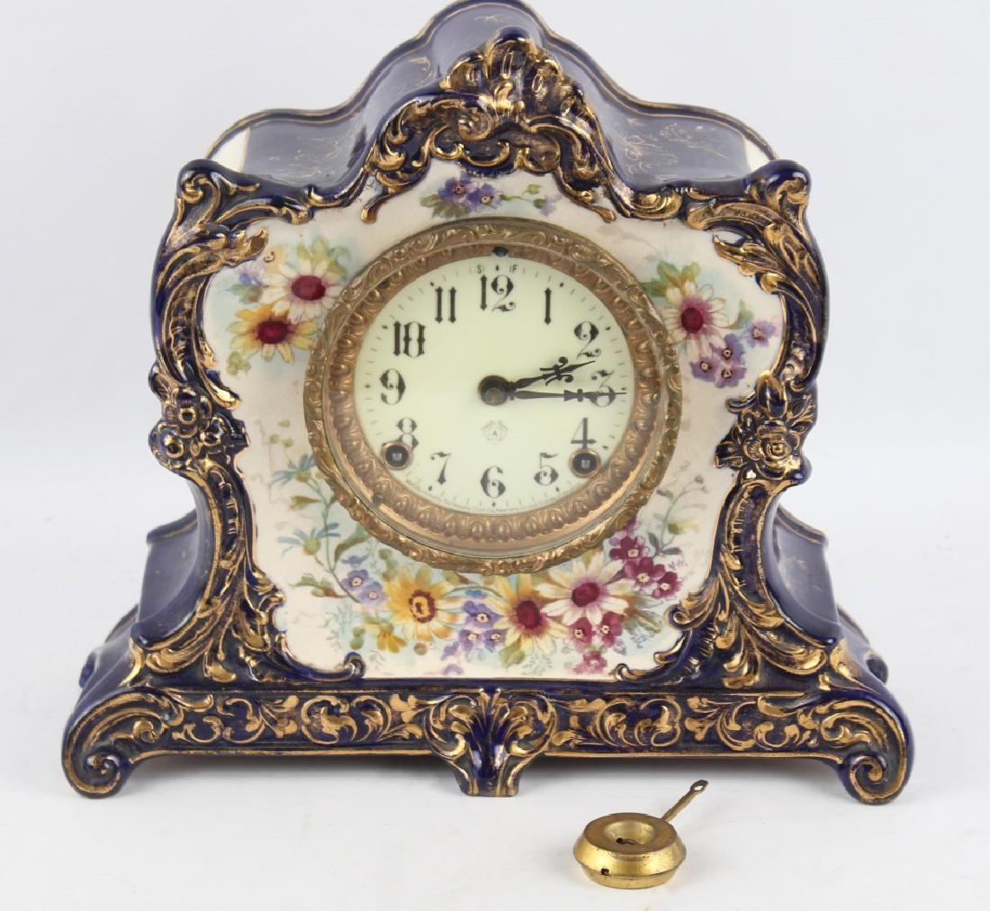 PORCELAIN CASE ANSONIA ROYAL BONN "LALORNE" CLOCK: PORCELAIN CASE ANSONIA ROYAL BONN "LALORNE" CLOCK Ansonia Royal Bonn "Lalorne". Porcelain clock with case - no damage to case noted. Rare cobalt blue, very little loss to gold leaf trim. Size: 12" x 1