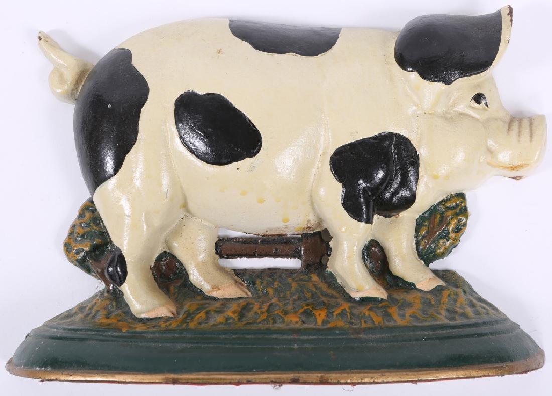 CAST IRON PIG AMERICANA DOORSTOP: CAST IRON PIG AMERICANA DOORSTOP Cast iron doorstop in the form of a pig, painted black and white with gold trim at base. Size: 8.5 x 13 x 3.25"