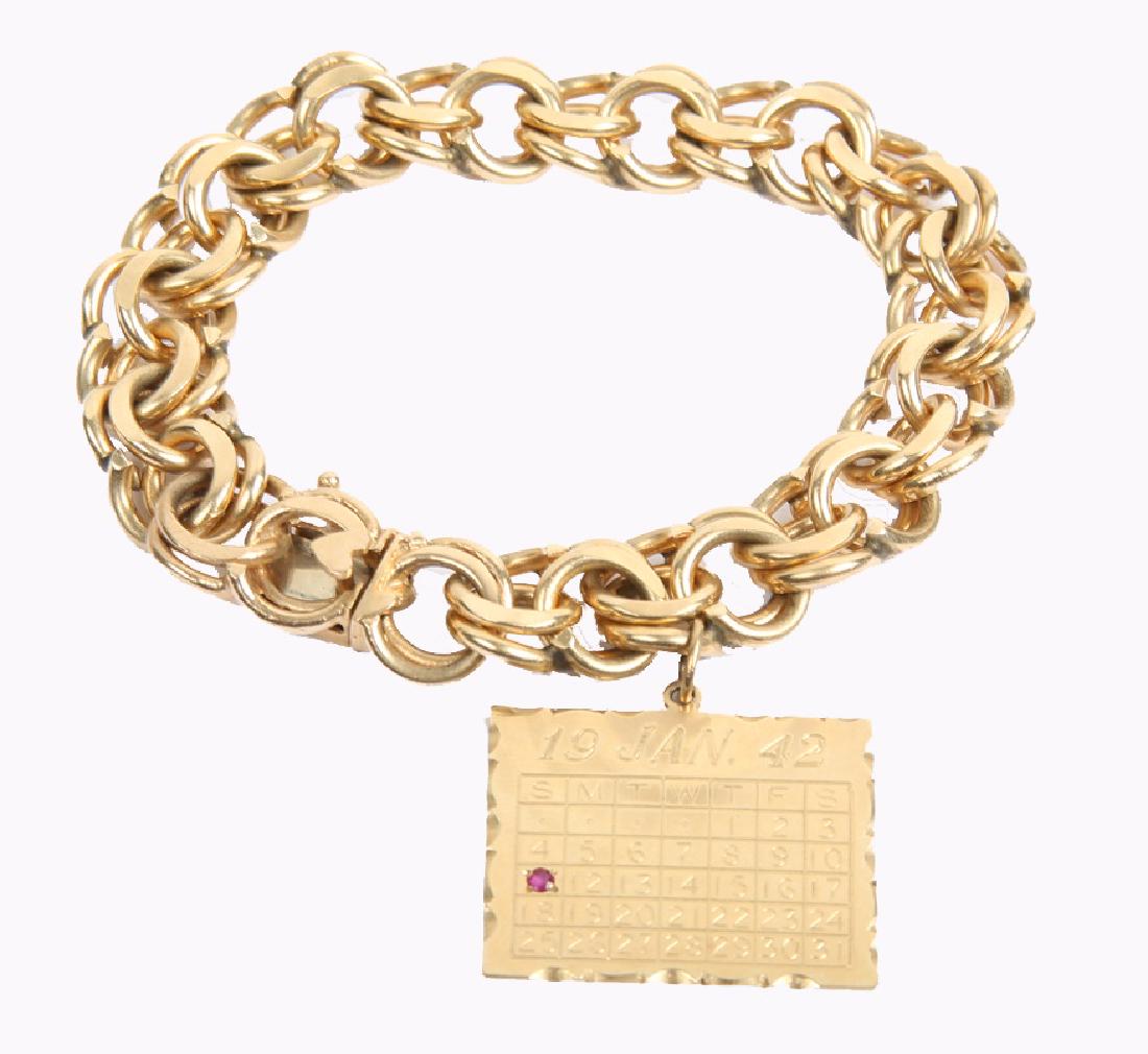 LADIES 14K YELLOW GOLD CHARM BRACELET: LADIES 14K YELLOW GOLD CHARM BRACELET 14k yellow gold chain link charm bracelet with one charm, calendar with ruby accent. Weight: 76.6 grams Size: 8.5"