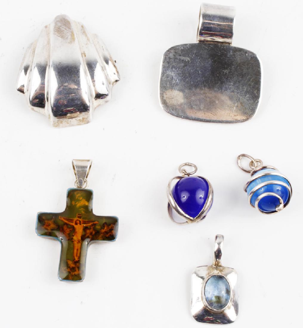 LOT OF SIX STERLING SILVER PENDANTS - ASSORTED: LOT OF SIX STERLING SILVER PENDANTS - ASSORTED Dealers lot of six assorted sterling silver pendants including cats eye, blue topaz and acrylic covered photo cross. Weight: 31.0 g