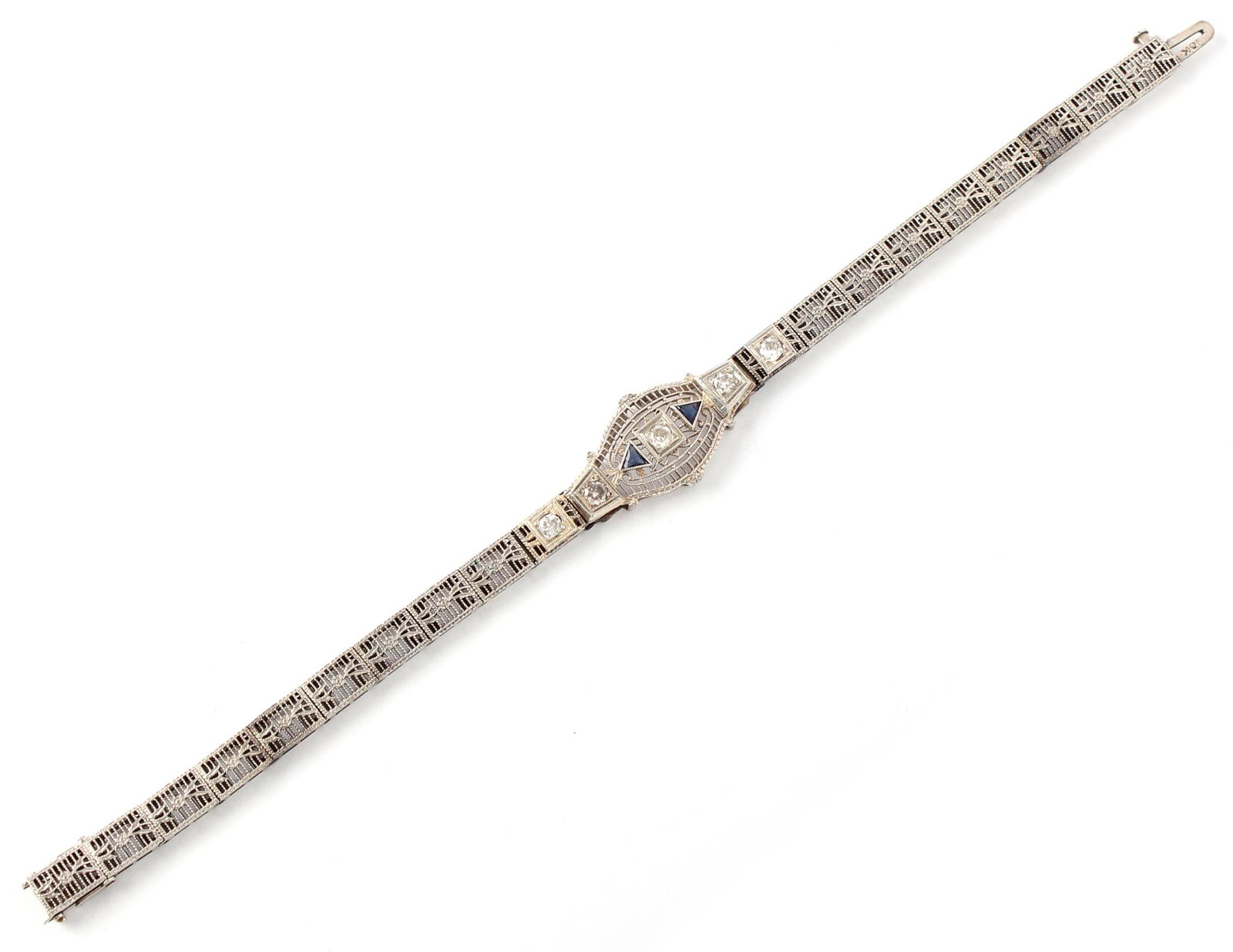 10K WHITE GOLD ANTIQUE DIAMOND SAPPHIRE BRACELET: 10K WHITE GOLD ANTIQUE DIAMOND SAPPHIRE BRACELET Ladies art deco 10k white gold filigree link bracelet featuring two triangle cut blue sapphires accenting four .07ct white diamonds. Weight: 7.0 grams 