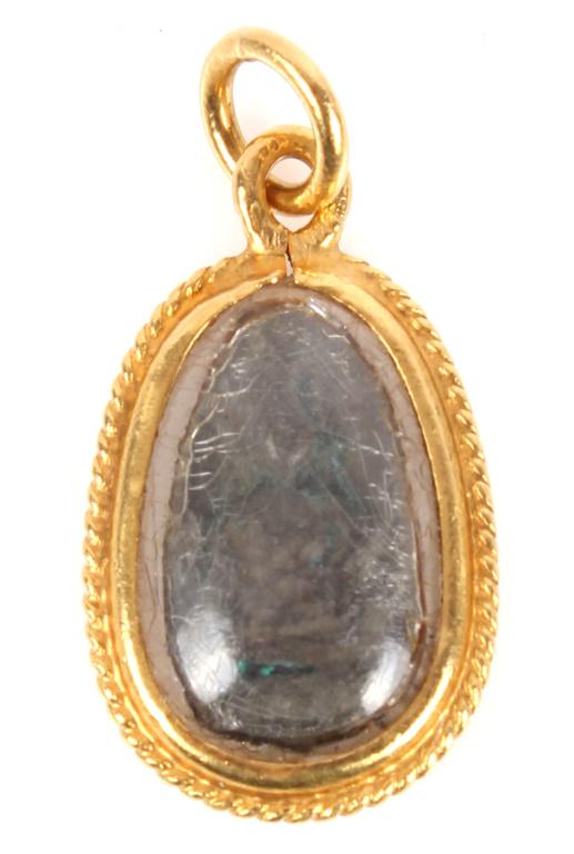 LADIES 22K YELLOW GOLD PHRA BUDDHA STONE AMULET: LADIES 22K YELLOW GOLD PHRA BUDDHA STONE AMULET 22k yellow gold bezel cased stone "phra somdej" Thai amulet necklace pendant depicting seated Buddha Weight: 2.8 gramsSize: 1"