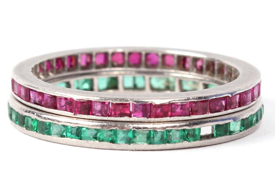 18K WHITE GOLD EMERALD & RUBY ETERNITY BANDS: 18K WHITE GOLD EMERALD & RUBY ETERNITY BANDS Lot of two ladies 18k white gold eternity bands, one with red ruby accents and one with green emeralds. Weight: 3.0 gramsSize: 5.75