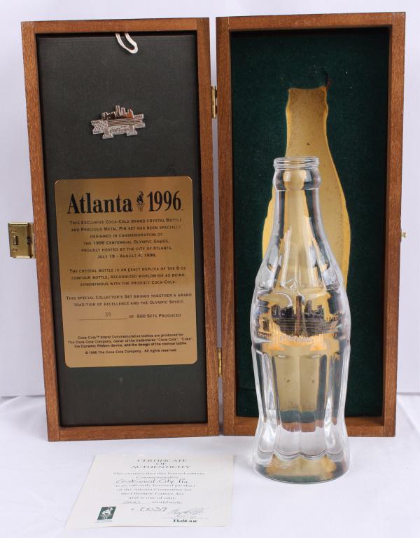 OLYMPIC ATLANTA 1996 COCA COLA BOTTLE AND C.O.A.: OLYMPIC ATLANTA 1996 COCA COLA BOTTLE AND C.O.A. Commemorative solid crystal glass Coca Cola bottle from the Atlanta centennial 1996 Olympics. Includes certificate of authenticity, centennial city pin