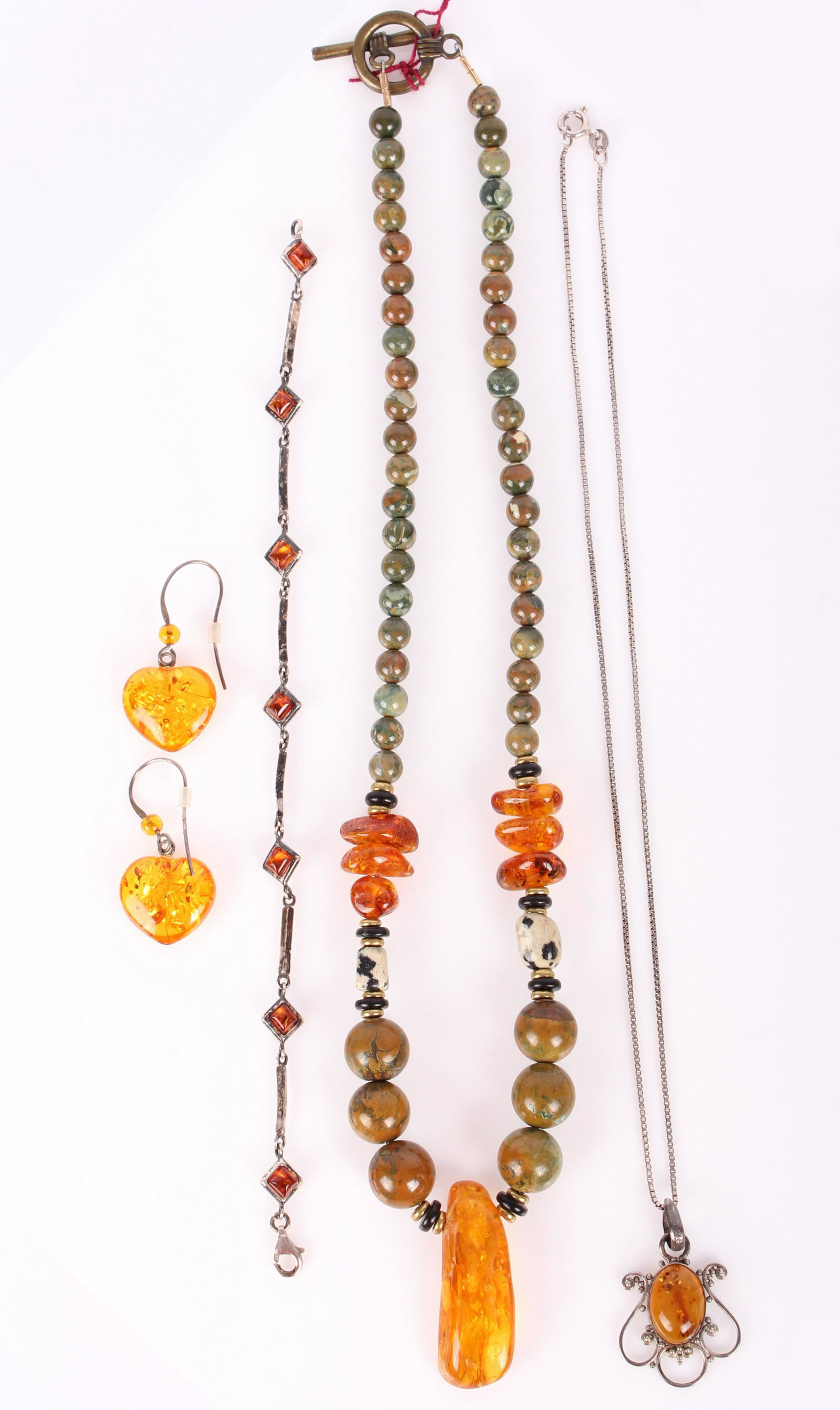 STERLING SILVER & AMBER LADIES JEWELRY LOT OF 5: STERLING SILVER & AMBER LADIES JEWELRY LOT OF 5 Sterling silver & amber jewelry to include one ladies sterling amber bracelet, one pair of amber heart earrings, one amber jasper and dalmation stone ne