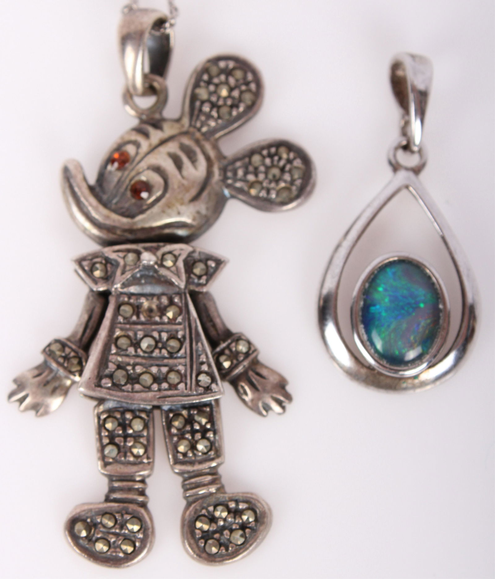 MICKEY MOUSE STERLING PENDANT NECKLACE & OTHER: MICKEY MOUSE STERLING PENDANT NECKLACE & OTHER Sterling silver pendants to include a Mickey Mouse marcasite pendant and a faux opal tear drop pendant. Includes a very thin sterling necklace. Weight: 8