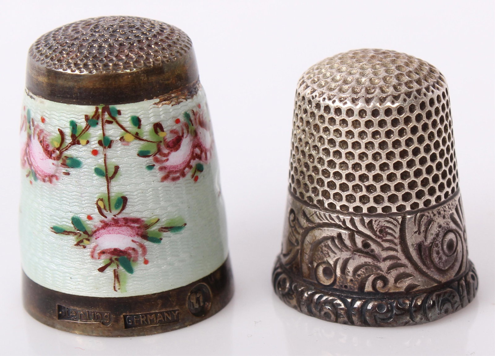 ANTIQUE STERLING SILVER SEWING THIMBLES - LOT OF 2: ANTIQUE STERLING SILVER SEWING THIMBLES - LOT OF 2 Antique sterling silver thimbles to include one German enameled floral thimble and one Sterling marked ornate thimble. Weight: 13.0 Grams Size: 1" La